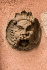 Fototapeta na wymiar Stone head of a bearded man on an old building of the historical town