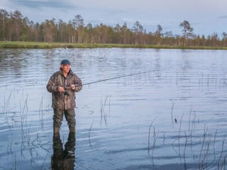 Active holidays outdoor, in Karelia. A man fishing in lake. Landscape of lake in North