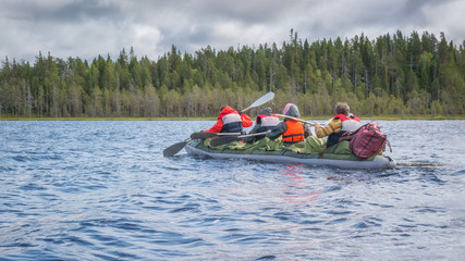 Family in kayak. Active extreme holidays in Karelia. Water rafting in North lakes and rivers. Landscape of harsh Karelian nature