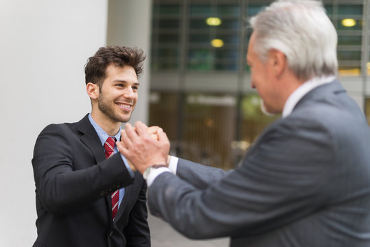 Boss holding the hands of an employee