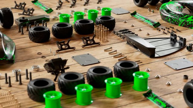 RC car parts and chassis laid out on a wooden workbench