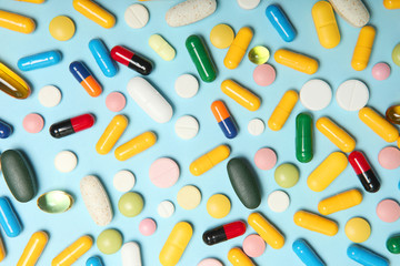 pills on a colored background top view. Medicine, treatment, illness. Medication in tablets.