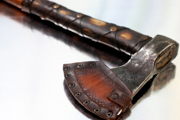 hand-forged axe close-up. decorated with leather and cover