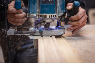 Milling a wooden part. A joiner processes a wooden product.