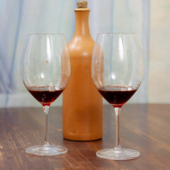 a bottle of homemade wine with two glasses on the table