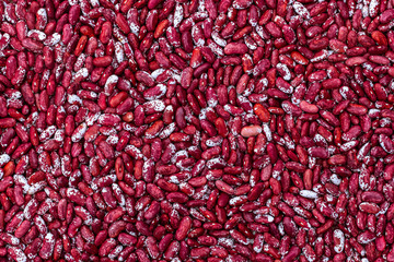 Top view of a heap of raw red beans. Red and white beans texture background.