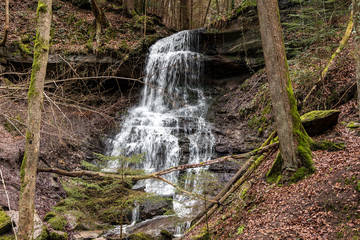 Little waterfall down the canyon in the middle of the green forest
