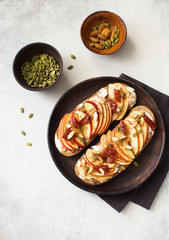 Open sandwiches with apple, jam, pumpkin seeds and almond. Flat lay