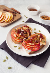 Open sandwiches with apple, jam, pumpkin seeds and almond close up.