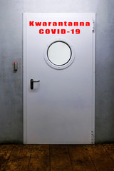 Armored door with the words Quarantine covid-19 in Polish.