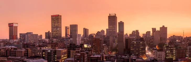 Ein wunderschönes und dramatisches Panoramafoto der Skyline von Johannesburg, aufgenommen an einem goldenen Abend nach Sonnenuntergang. © Udo Kieslich