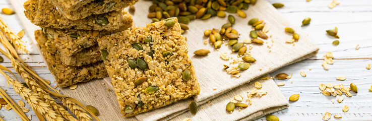 Multigrain Cereal Crunchy Squares Bars with Pumpkin Seeds on Wooden Background. Selective focus.