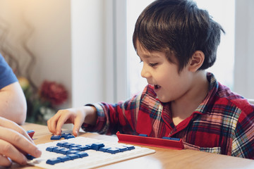 Preschool kid playing English words game,Child boy concentrated with spelling English letter with parent at home. Activity for children for play and learn, Education and Homeschooling  concept