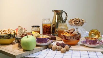 On the table there are sweets: cake, dry fruits, nuts and jam view