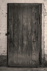 Old wooden door in brick wall, background texture