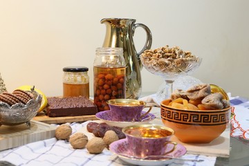 On the table there are sweets: cake, dry fruits, nuts and jam view