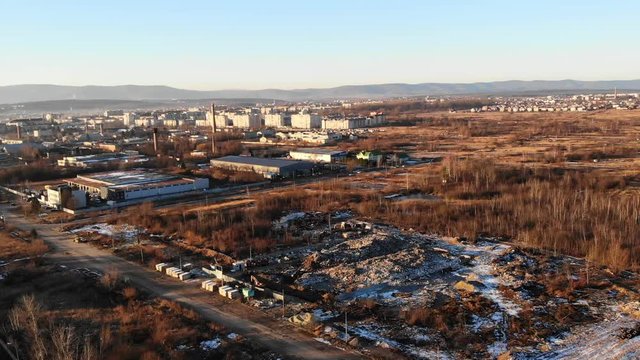 Huge heaps of garbage on the outskirts of the city. The theme of ecology and pollution, conservation of clean environment and nature. Aerial drone view of a landfill site, zoom in