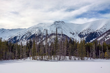 Winter panorama of West Tatra mountain range from frozen and snow-covered Smreczynski Lake (Smreczyński Staw), Poland