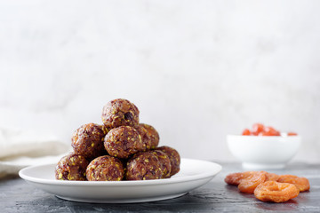 Energy balls with dried apricots, raisins, pistachios and dried cherrys. Vegan food. Raw diet. Good nutrition concept. White concrete background with copyspace from above. Middle view.