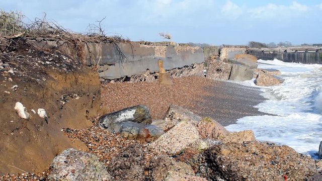 Waves battering the damaged sea defence at Climping Beach, West Sussex, UK