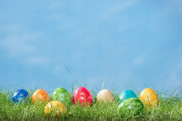 Easter eggs in spring grass with cloudy sky