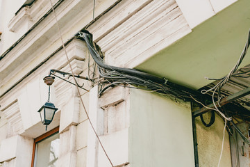 A lot electric wires on the facade of old building. Electricity. Electric communication for...