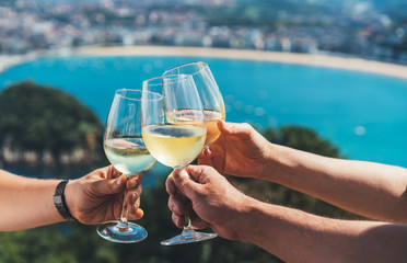 Drink two glasses white wine in friends hands outdoor seascape holidays
