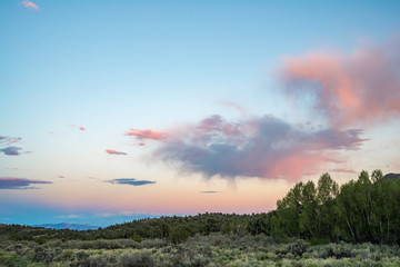 Fototapeta na wymiar Pastel Colors fill the Big Sky above the Great Basin Desert in Eastern Nevada. Aplenglow lights Ward Mountain far in the distance during blue hour after sunset.