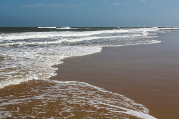 Storm on the beach. A long sea wave on a sandy ocean beach.
