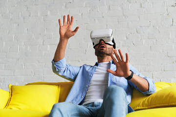 Portrait of amazed excited man watching virtual reality glasses with open mouth expression