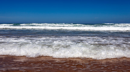 Fototapeta na wymiar Storm on the beach. Oceanic long wave on a sandy beach .