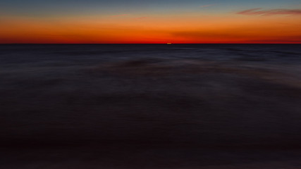 Fototapeta na wymiar calm sea at sunset, a moment before the sun disappears behind the horizon