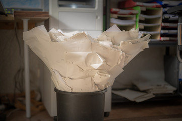 Überfüllter Papierkorb in einem Büro als Zeichen von hohem Papierverbrauch und Argument für die...