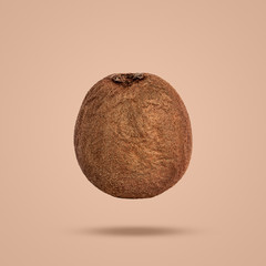flying ripe kiwi isolated on brown background