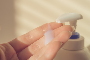 Female hand with white wet soap drop on fingers