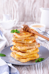 Fresh homemade crispy toast with honey on white wooden table