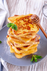 Fresh homemade crispy toast with honey on white wooden table