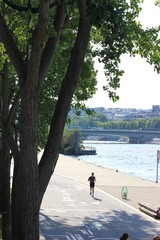 A jogger on the waterfront of the Seine River in Paris, France