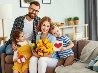 happy mother's day! father and children congratulate mother on holiday  .