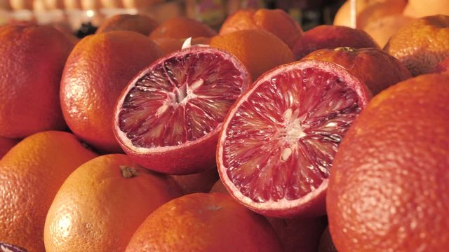 Close-up of a fresh crimpson oranges on fruit market. Boxes full of ripe oranges on farmers market. Organic fruits display in a supermarket. Juicy blood oranges at the greengrocer's stall. Harvest of