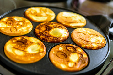 pancake frying pan with smile face pancake cooking on cooker in kitchen