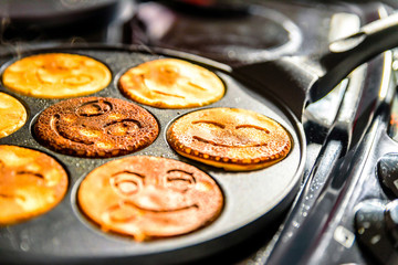 pancake frying pan with smile face pancake cooking on cooker in kitchen