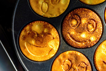 pancake frying pan with smile face pancake cooking on cooker in kitchen