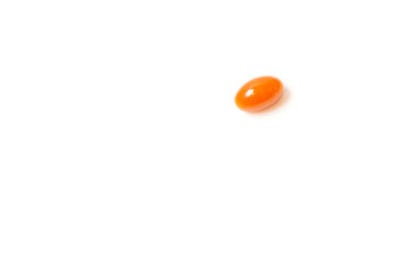 One orange tablet lies on a white background. View from above