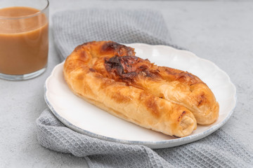 Bulgarian Savory Cheese Pie Banitsa (Banitza) with a cup of boza on nutral background