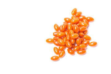 A lot orange tablets lie on a white background. Isolate