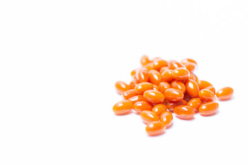 A lot orange tablets lie on a white background