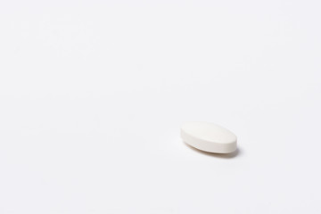 One white tablet oval shaped on a white background