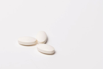 Three white tablet oval shaped on a white background. Isolated