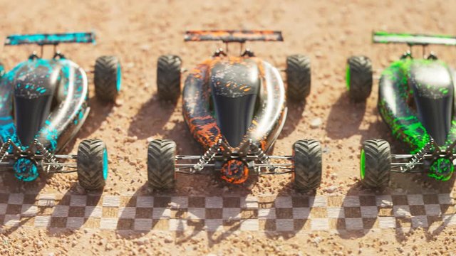 Multiple colourful remote-controlled buggy cars on start line in the desert.